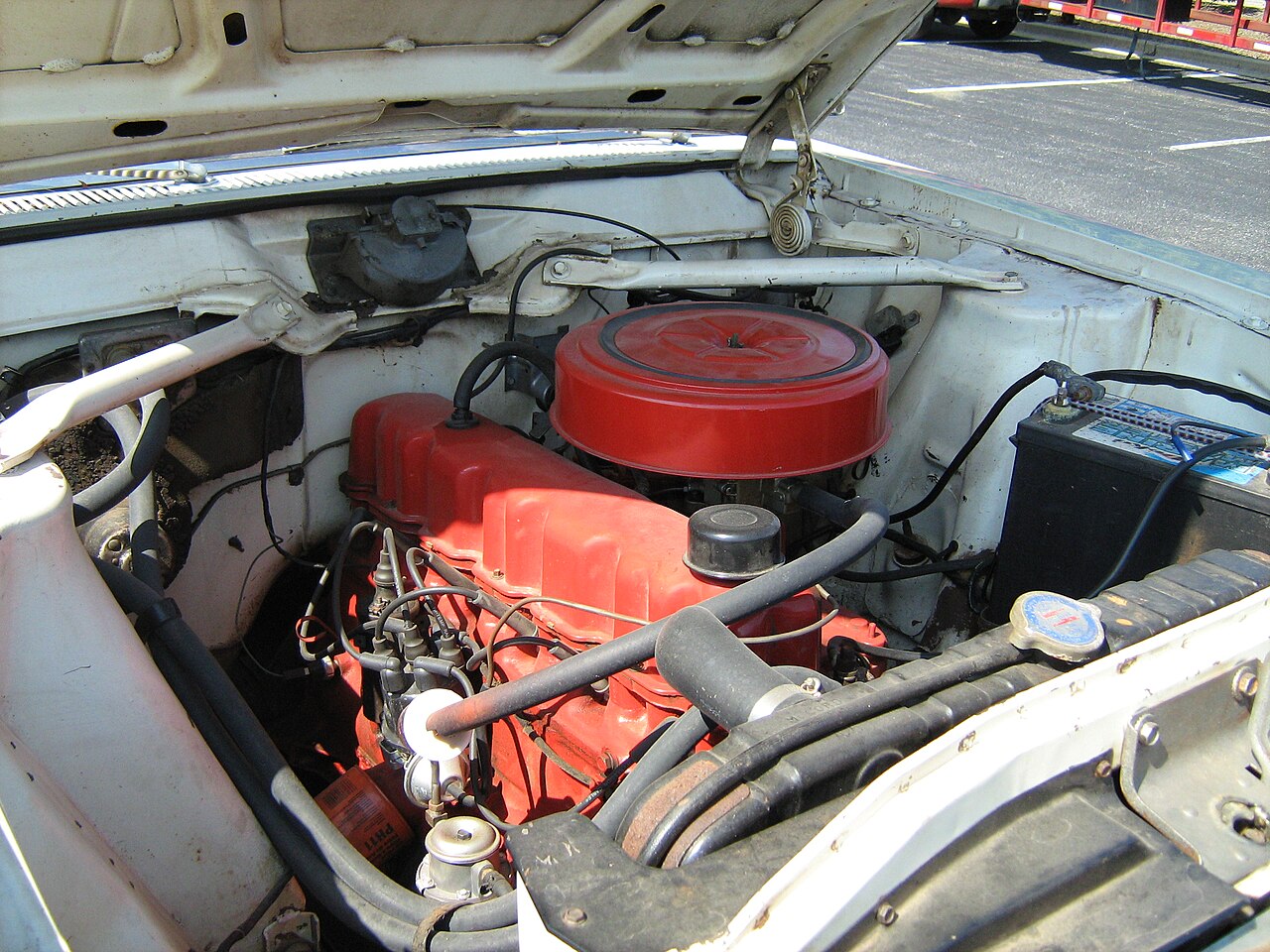 Volkswagen aracın motor bölmesinde akü değişimi yapılırken kutup başı sökülüyor.